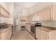 Spacious kitchen featuring tile flooring, a built-in desk, and stainless steel appliances at 15011 W Verde Ln, Goodyear, AZ 85395