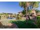 Lush backyard featuring a well-maintained lawn, a pool, and mature palm trees, creating a private oasis at 16178 W Granada Rd, Goodyear, AZ 85395