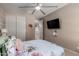 A well-lit bedroom with a ceiling fan, closet, and a mounted television for comfortable, modern living at 16178 W Granada Rd, Goodyear, AZ 85395