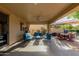 Expansive covered patio with a ceiling fan, an outdoor dining set, and comfortable seating, perfect for entertaining at 16178 W Granada Rd, Goodyear, AZ 85395