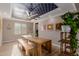 Bright dining room featuring a decorative ceiling, modern lighting, a large table and an adjacent plant stand at 16178 W Granada Rd, Goodyear, AZ 85395