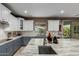 Gourmet kitchen showcasing a large island with a sink, custom cabinetry, and modern appliances at 16178 W Granada Rd, Goodyear, AZ 85395