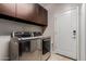 Modern laundry room with stainless steel washer and dryer, and upper cabinets at 16178 W Granada Rd, Goodyear, AZ 85395
