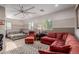 Spacious living room and bedroom suite with a large ceiling fan, windows and a red sofa at 16178 W Granada Rd, Goodyear, AZ 85395