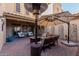 Inviting patio with comfortable seating arrangements, a fire pit, and a shade umbrella for outdoor enjoyment at 16178 W Granada Rd, Goodyear, AZ 85395