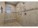 Walk-in shower with multiple shower heads, tile surround and seating at 16178 W Granada Rd, Goodyear, AZ 85395