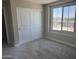 Bright bedroom with neutral carpet, closet, and a large window with natural light at 18365 W Villa Hermosa Ln, Surprise, AZ 85387