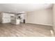 Open-concept living space with wood-look tile flooring and a modern kitchen at 18365 W Villa Hermosa Ln, Surprise, AZ 85387