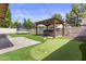 Lush backyard featuring a putting green, trampoline, hot tub under a pergola, and artificial turf at 190 E Tremaine Ave, Gilbert, AZ 85234