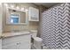 Cozy bathroom with granite countertop, updated lighting, and decorative chevron shower curtain at 190 E Tremaine Ave, Gilbert, AZ 85234