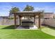 Relaxing backyard hot tub under a wooden pergola with artificial turf and putting green at 190 E Tremaine Ave, Gilbert, AZ 85234