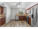Well-lit kitchen features stainless steel appliances, granite countertops, and stylish wood flooring at 190 E Tremaine Ave, Gilbert, AZ 85234