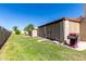 A spacious backyard features a grill, manicured grass, and a tall privacy fence at 2059 E Brown Rd # 35, Mesa, AZ 85213