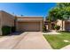 Beige home showcasing an attached two-car garage, desert landscaping and an arched doorway at 2059 E Brown Rd # 35, Mesa, AZ 85213