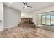 Spacious living room featuring wood-look flooring, gray accent wall and brick fireplace at 2059 E Brown Rd # 35, Mesa, AZ 85213