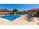 Community pool surrounded by lush greenery and a covered seating area with tables, perfect for relaxation and socializing at 2059 E Brown Rd # 35, Mesa, AZ 85213