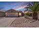 Charming single-story home with desert landscaping, two-car garage and palm tree at 22993 W Micah Way, Buckeye, AZ 85326