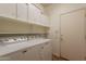 Functional laundry room with washer, dryer, shelving, and storage at 22993 W Micah Way, Buckeye, AZ 85326