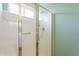 Bright bathroom shower with glass door, grab bar, and window at 22993 W Micah Way, Buckeye, AZ 85326