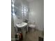 The well-lit bathroom has a pedestal sink and a modern toilet at 2311 E Hartford Ave # 38, Phoenix, AZ 85022
