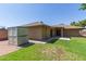 Backyard featuring a green lawn, storage shed, and partial view of the house exterior at 2956 E Concho Ave, Mesa, AZ 85204