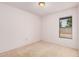 A well-lit secondary bedroom offers neutral walls and carpet and a large window at 2956 E Concho Ave, Mesa, AZ 85204