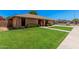 Well-manicured front yard of a brick home with a lovely, green lawn and mature landscaping at 2956 E Concho Ave, Mesa, AZ 85204