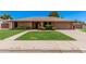 Charming brick home featuring a lush front yard and inviting curb appeal at 2956 E Concho Ave, Mesa, AZ 85204