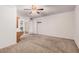 A spacious primary bedroom features neutral carpet, a ceiling fan and ensuite bathroom and walk-in closet at 2956 E Concho Ave, Mesa, AZ 85204