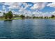 Picturesque lake view with lush greenery, mature trees, and a peaceful waterfall feature for community enjoyment at 2990 N Pearl Ct, Casa Grande, AZ 85122