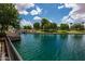 Scenic lake view with lush landscaping, mature trees, and a bridge in a serene community setting at 2990 N Pearl Ct, Casa Grande, AZ 85122
