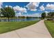 Picturesque view of a lake and walking path surrounded by green grass and mature trees in a serene community setting at 2990 N Pearl Ct, Casa Grande, AZ 85122