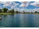 Picturesque community lake featuring mature trees, landscaping, and a tranquil waterfall feature at 2990 N Pearl Ct, Casa Grande, AZ 85122