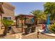 Stylish pergola with an outdoor bar, seating, and beautiful landscaping in the backyard at 2990 N Pearl Ct, Casa Grande, AZ 85122