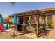Backyard with a pergola featuring a bar, chairs, and swing, perfect for relaxation at 2990 N Pearl Ct, Casa Grande, AZ 85122