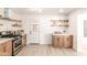 Bright kitchen with white cabinets, stainless steel appliances, and floating wood shelves at 3118 W Windrose Dr, Phoenix, AZ 85029