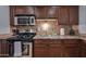 Updated kitchen features stainless steel appliances, tile backsplash, and wood cabinets at 357 E Thomas Rd # A208, Phoenix, AZ 85012