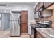 Updated kitchen features stainless steel appliances, tile backsplash, and wood cabinets at 357 E Thomas Rd # A208, Phoenix, AZ 85012