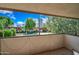 Patio view of a lush community with mature trees, a pool, and mid-rise buildings at 357 E Thomas Rd # A208, Phoenix, AZ 85012