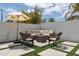 Cozy backyard patio with comfortable seating, an umbrella, and artificial turf, perfect for outdoor relaxation at 3814 N 36Th St, Phoenix, AZ 85018