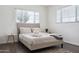 Bright bedroom featuring a tan upholstered bed frame, wood floors and two windows at 3814 N 36Th St, Phoenix, AZ 85018