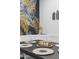 Close-up of a dining table featuring decorative placemats, a gold centerpiece, a statue, and a unique gold leaf wall behind at 3814 N 36Th St, Phoenix, AZ 85018