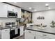 Modern kitchen features sleek stainless steel appliances, white cabinets, gray countertops, and an adjacent stylish dining area at 3814 N 36Th St, Phoenix, AZ 85018