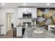 Stylish kitchen featuring stainless steel appliances, white cabinets, a trendy island, and an adjacent dining nook with unique wall decor at 3814 N 36Th St, Phoenix, AZ 85018