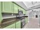 The kitchen features updated stainless appliances, stone countertops and bright green cabinets at 3825 E Camelback Rd # 182, Phoenix, AZ 85018