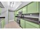 The kitchen features updated stainless appliances, stone countertops and bright green cabinets at 3825 E Camelback Rd # 182, Phoenix, AZ 85018