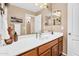 Bathroom featuring wood cabinets, white countertop, decorative mirror and stylish fixtures at 38771 N Dena Dr, San Tan Valley, AZ 85140
