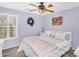 Bedroom featuring a ceiling fan, window with white shutters, and lilac walls at 38771 N Dena Dr, San Tan Valley, AZ 85140
