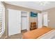 Secondary bedroom with ample storage, including sliding closet doors and a TV at 38771 N Dena Dr, San Tan Valley, AZ 85140