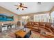 Comfortable living room boasts a modern fireplace, leather sectional, and backyard access at 38771 N Dena Dr, San Tan Valley, AZ 85140